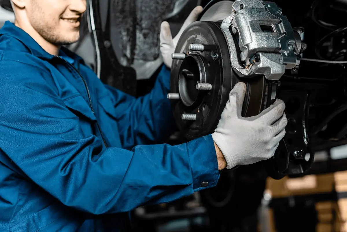 Signs of bad brakes – A mechanic inspecting brake disc and caliper during vehicle brake service